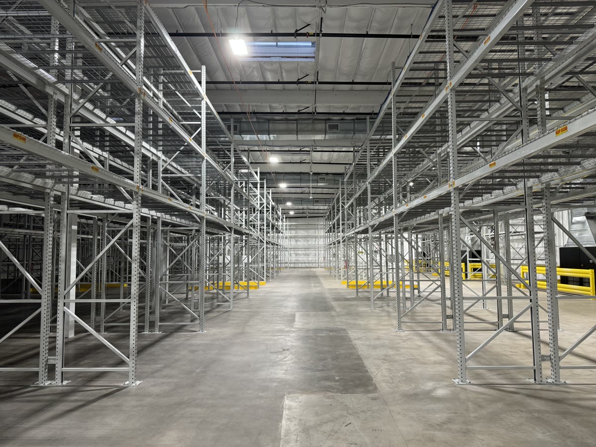 Tall galvanized selective pallet racking lining a wide central aisle in a Vernon, CA fine art storage warehouse
